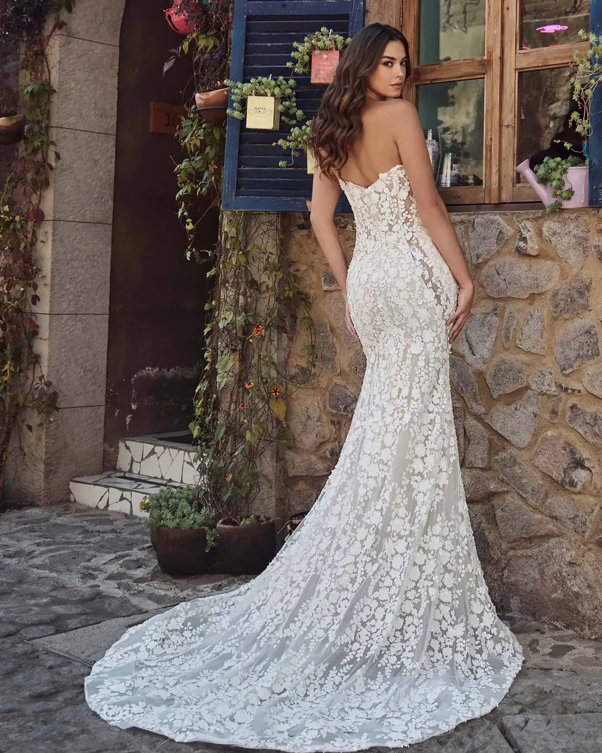 model is wearing a lace strapless fit and flare wedding dress with detachable optional long sleeves