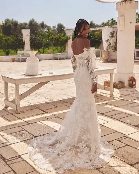 model is wearing an off the shoulder lace wedding dress