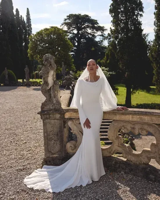 model is wearing a long sleeve minimalist weding dress