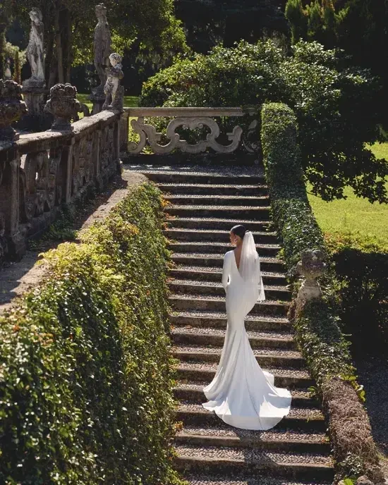model is wearing a long sleeve minimalist weding dress