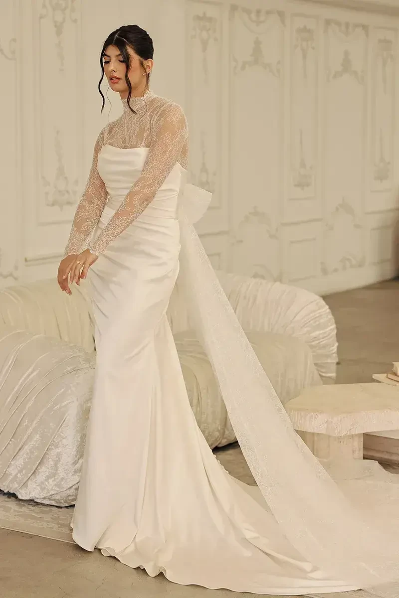model is wearing a long sleeve high neckline wedding dress